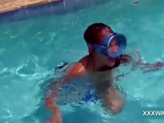 Cao cậu bé tóc nâu đường phố cô gái cục kẹo swims dưới nước